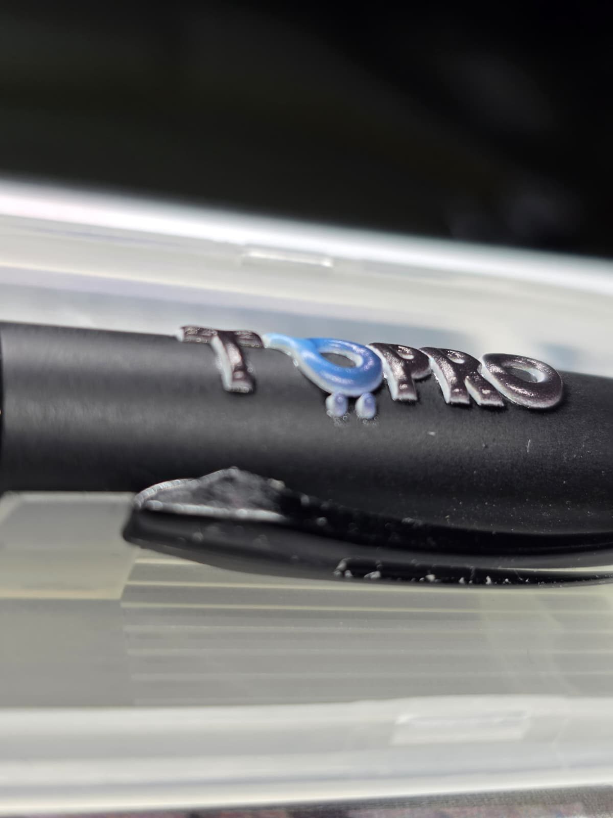 Blurry close-up photo of a pen with logo print.