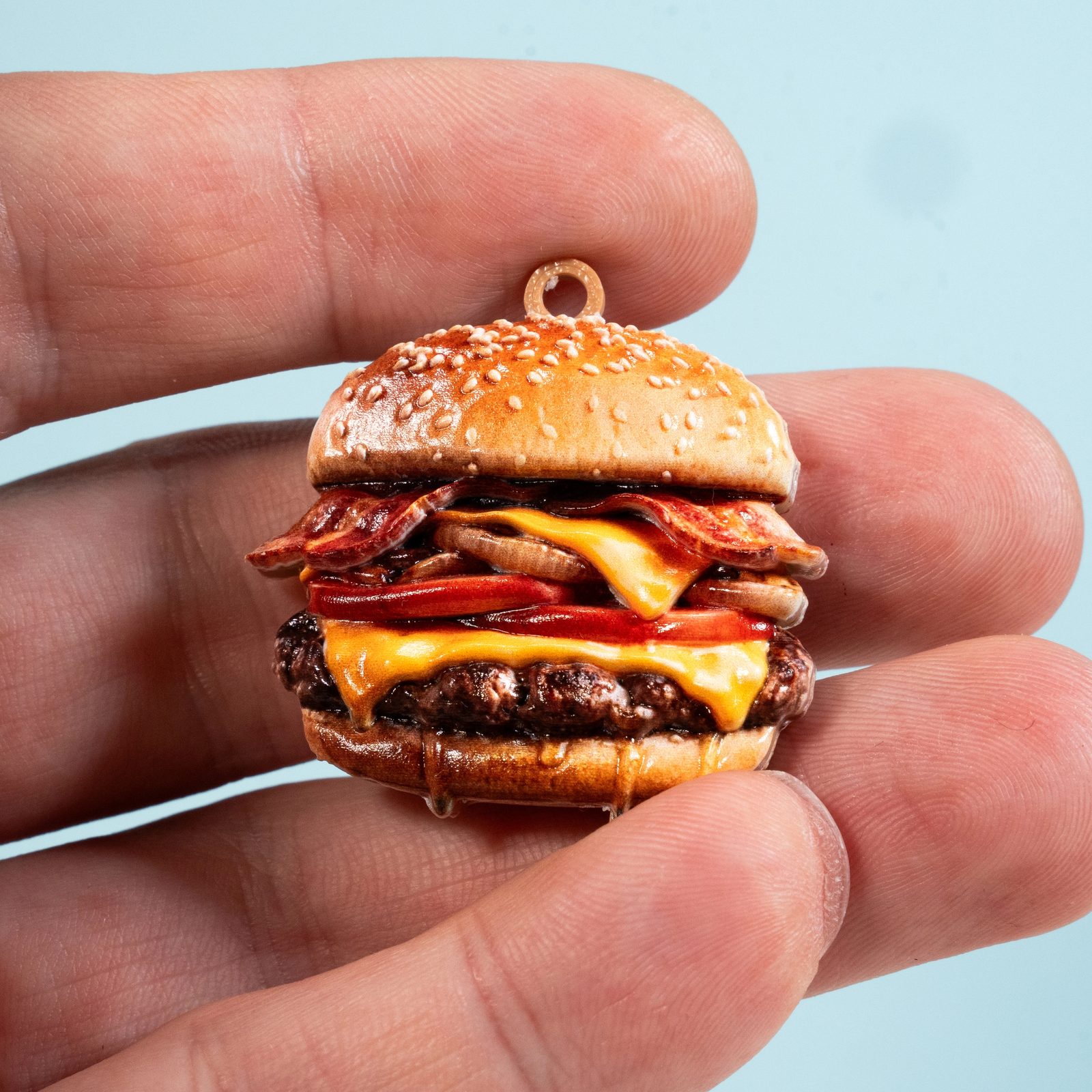 Miniature hamburger charm with realistic layered details.